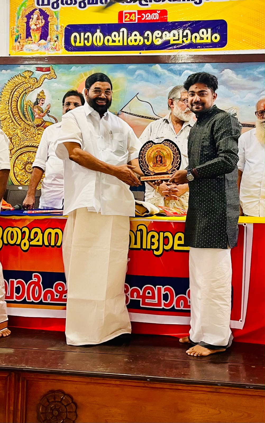 Akhil being honoured on stage with a plaque