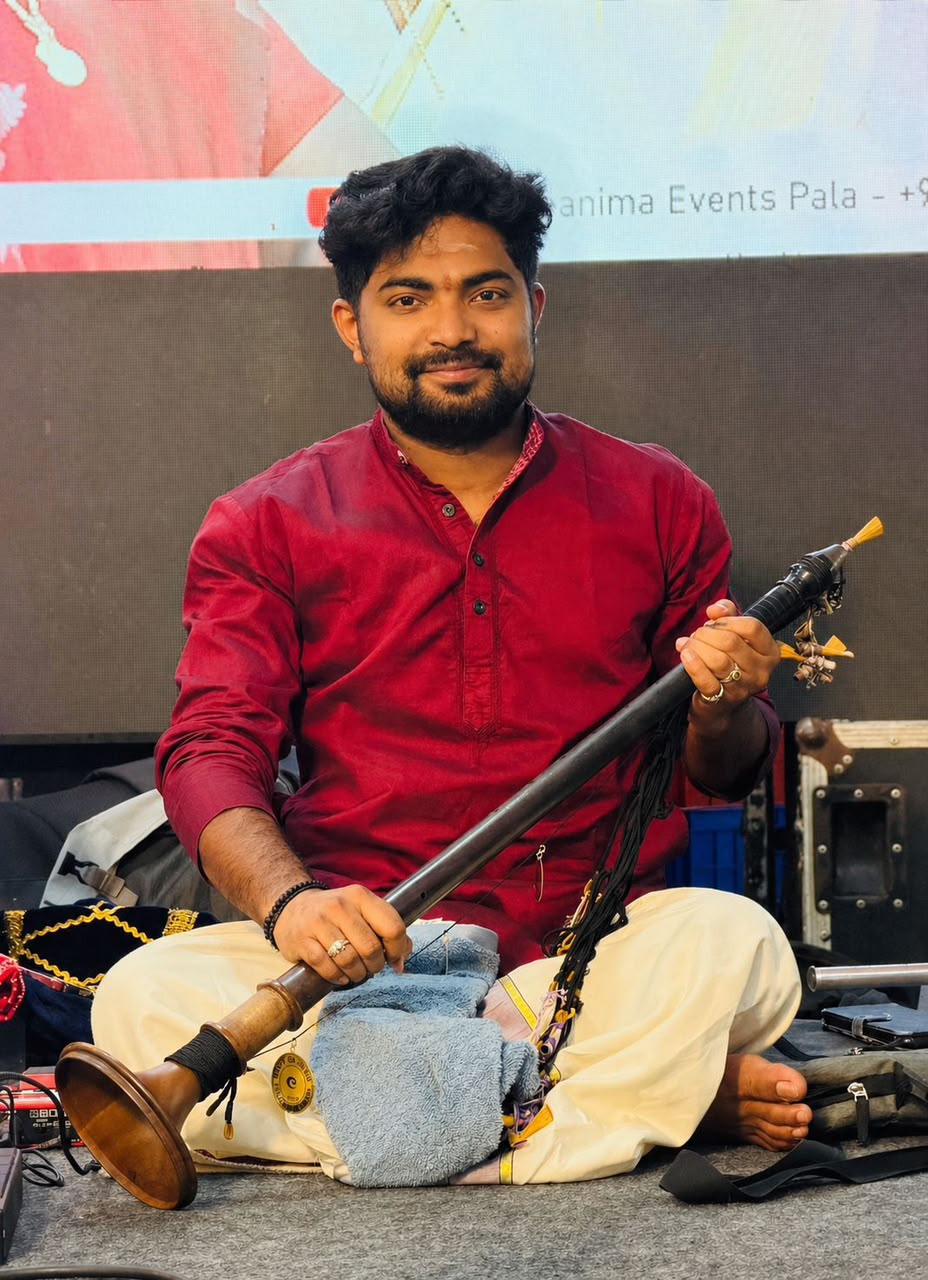 Akhil performing on stage in crimson kurta